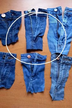 several pairs of jeans laid out on a wooden surface with a circle in the middle