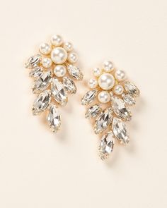 Head turning, bold & floral, our Verona Earrings are the perfect way to make a statement. Add a touch of sophistication and sparkle when you wear these earrings for weddings, black tie events or even your next girls night out. Details: Multiple sized, light ivory pearls look like a flower. Top grade rhinestones for high shine (day or night). Specifications: 2" in length x 1.25" wide. Earrings are slightly heavier than some, but worth it! Tarnish Resistant: Earrings are tarnish resistant for long Classic Bridal Earrings With Elegant Design For Party, Elegant Party Pearl Earrings For Pierced Ears, Elegant Evening Cluster Clip-on Earrings, Classic Drop Clip-on Earrings For Party, Elegant Clip-on Cluster Earrings For Evening, Classic Drop Pearl Earrings For Party, Silver Glamorous Cluster Earrings For Party, Glamorous Party Cluster Earrings With Sparkling Stones, Elegant Silver Pearl Earrings For Party