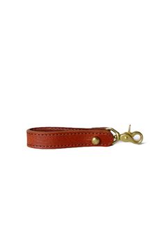 a red leather keychain with brass hardware