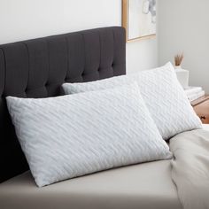 two white pillows on top of a bed