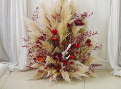 an arrangement of dried flowers and foliage on the floor