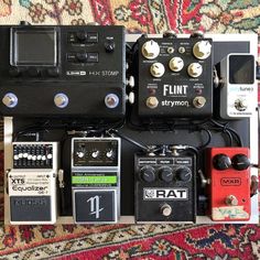 an assortment of pedals and amps are arranged on top of a carpeted area