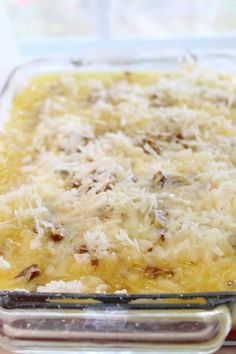 a casserole dish with cheese and other toppings in a glass baking dish