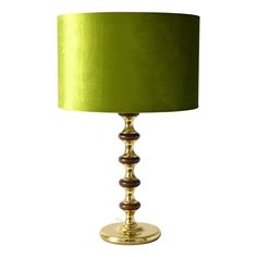 a green lamp on a white background with a gold base and dark brown trim around the shade