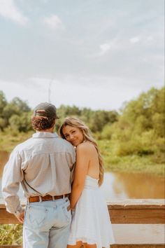 a man and woman standing next to each other on a bridge