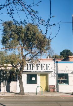 an old building with a tree in front of it and a sign that says coffee