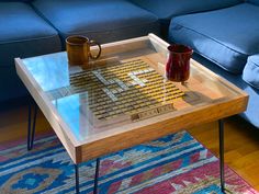 a coffee table with two mugs on it in the middle of a living room