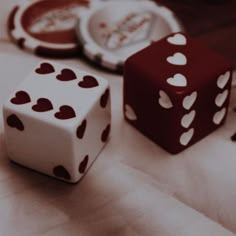 two dices sitting next to each other on top of a white cloth covered table