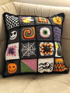 a crocheted pillow is sitting on a chair with a white cushion and black background