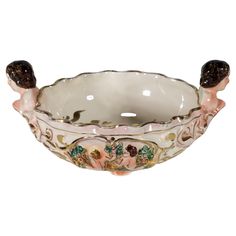 a white bowl with pink and gold designs on the rim, sitting on a white surface