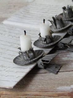 two candles are sitting on top of some pieces of metal that have been placed together