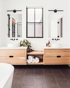 a bathroom with two sinks, mirror and bathtub in it's own area