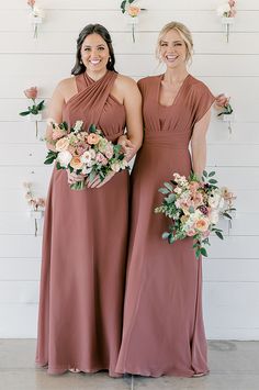 two women standing next to each other holding bouquets