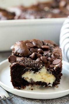 a piece of chocolate cake on a plate with ice cream and chocolate chips in the middle