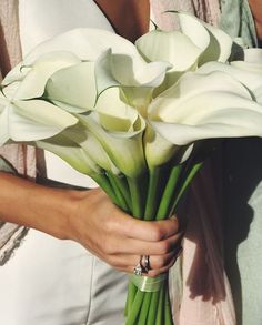 a woman holding a bouquet of white flowers