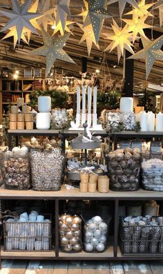 christmas decorations and candles are on display in the store's window sill, with hanging stars above them