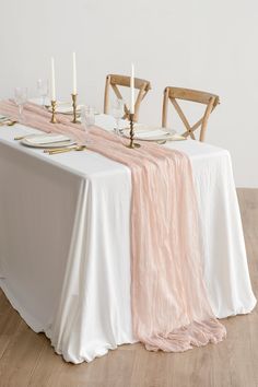 the table is set with white and pink linens