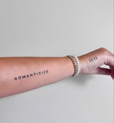 a woman's arm with roman numerals on it and the word romanticize written in black ink