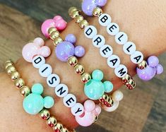 the disney bracelets are all different colors and designs on each one arm, with mickey mouse charms attached to them