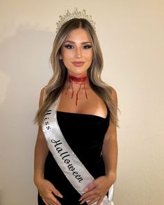 a woman wearing a tiara with blood on her face and the words miss halloween written across it