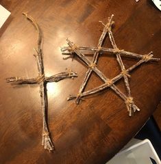 three crosses made out of sticks on top of a wooden table