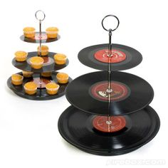 cupcakes are arranged on three tiered trays with vinyl records attached to them