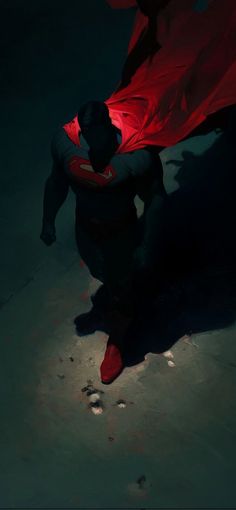 a man with a red cape sitting on the ground