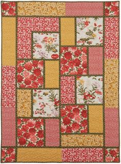 a red and yellow quilt with flowers on it