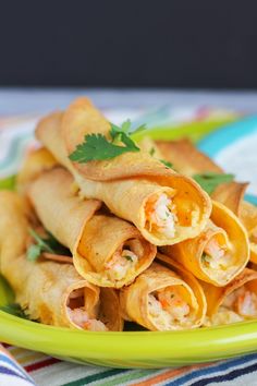 some food is on a green plate with a striped table cloth and colorful napkins