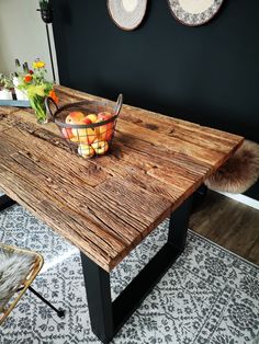 a bowl of fruit sitting on top of a wooden table next to a basket of fruit