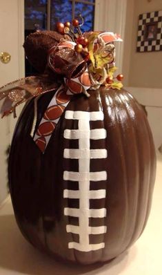 a decorated pumpkin with a football on it