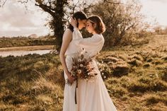 two women standing next to each other in a field