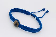 Es una pulsera con ojo de tigre y esta tejida con hilo color azul es ajustable y la usan hombres y mujeres (es pequeña se extiende asta 6 pulgadas de largo) Mirar las fotografías para más detalles excelente regalo para alguien muy especial  Gracias por su apoyo Casual Blue Macrame Bracelets, Handmade Blue Evil Eye Bracelet Casual Style, Adjustable Blue Evil Eye Bracelet With Sliding Knot, Casual Blue Macrame Braided Bracelets, Blue Evil Eye Bracelet With Adjustable Length, Casual Blue Friendship Bracelets With Evil Eye, Adjustable Evil Eye Casual Jewelry, Adjustable Casual Evil Eye Jewelry, Casual Adjustable Evil Eye Jewelry