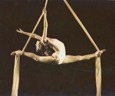 a man doing aerial acrobatic tricks on a rope