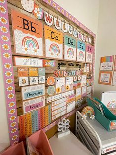 a child's room decorated in pink, orange and yellow with lots of letters on the wall