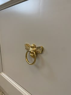 a bathroom door handle with a gold bee on it