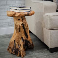 a wooden table sitting on top of a hard wood floor next to a white couch