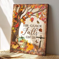 a wooden sign that says his grace falls on us with autumn leaves and pumpkins