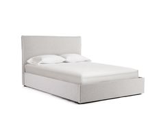 a bed with white sheets and pillows on it