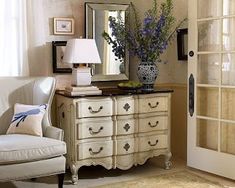 a living room filled with furniture and a large mirror on top of a dresser next to a window