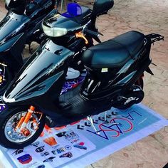 several motorcycles are lined up on the ground near one another and people looking at them