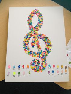 a sheet of paper with a musical note made out of colored dots