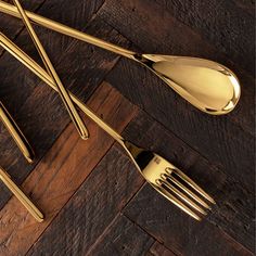 gold colored utensils and spoons on a wooden table with wood flooring