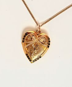 This is a rare beautiful vintage antique 14K gold filled heart locket with scroll design of Fleur-de-lis, floral etched and surrounded 16 stones around the edge. The locket has amazing engraved flowers. Inside the locket has a frame for picture. The backside is plain. This locket is charming piece of jewelry that is sure to steal your heart. A condition is excellent, with no damages or repairs. It hangs from 18" chain necklace that is marked 14K gold filled. Large locket measures 1 1/8" X 1" . Cheap Vintage Gold Locket Necklace, Valentine's Day Yellow Gold Jewelry With Intricate Design, Valentine's Day Gold Necklace With Intricate Design, Heirloom Heart-shaped Jewelry With Intricate Design, Victorian Heart Pendant Jewelry For Formal Occasions, Collectible Gold Jewelry With Heart Charm, Victorian Locket Jewelry For Valentine's Day, Victorian Locket For Valentine's Day, Victorian Yellow Gold Jewelry For Valentine's Day