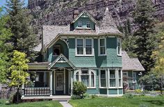 a green house with a mountain in the background