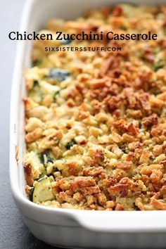 a casserole dish with zucchini and meat toppings in a white baking dish