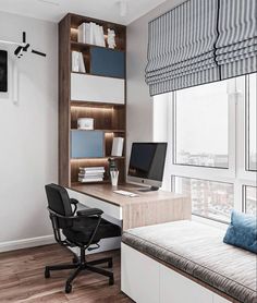 a desk with a computer on top of it next to a window in a room