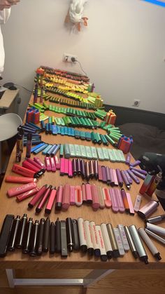 a table with many different types of pens and pencils laid out on top of it