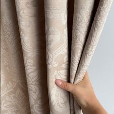 a hand is holding the curtain in front of it