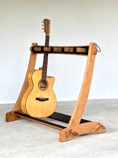 a wooden guitar stand holding an acoustic guitar